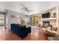 Cozy living room features a fireplace, a plush blue sofa, and a sliding glass door to the outside at 3785 Birchwood Dr # 72, Boulder, CO 80304