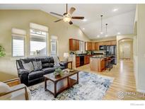 Open living room features a kitchen with island and vaulted ceiling at 1463 Moonlight Dr, Longmont, CO 80504
