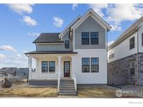 Two-story craftsman style home with gray and white exterior, front porch, and landscaping at 154 Westerly Blvd, Erie, CO 80516