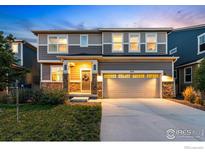 Charming two-story home with stone accents, well-maintained lawn, and welcoming front door at 457 Western Sky Cir, Longmont, CO 80501