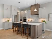 Modern kitchen with island, stainless steel appliances, and white cabinets at 1425 Burt Ave, Berthoud, CO 80513
