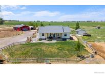 Lovely ranch-style home with fenced yard, red barn, and ample space at 10691 County Road 23, Fort Lupton, CO 80621