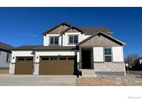 Two-story home with a three-car garage, stone accents, and a manicured lawn at 16810 Mckay Dr, Mead, CO 80542
