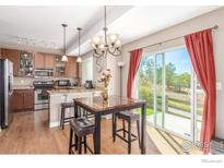 Inviting dining area adjoining kitchen with a modern chandelier and sliding door access to the outdoor patio at 12921 Grant W Cir # B, Thornton, CO 80241