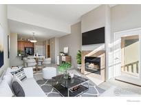 Open living room featuring a fireplace and ample natural light at 8467 Canyon Rim Cir # 306, Englewood, CO 80112