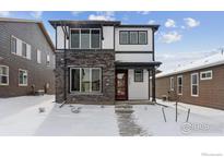 Two-story modern home with stone accents and a red door at 2787 Optimista Pl, Brighton, CO 80601