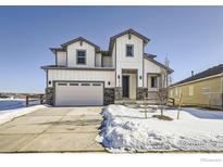 Two-story farmhouse style home with gray and white siding, stone accents, and a two-car garage at 12718 Bend Ct, Firestone, CO 80504