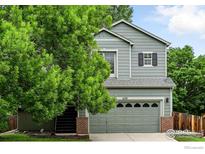 Charming two-story home with a well-maintained lawn and a two-car garage, complemented by mature trees at 608 Bluegrass Dr, Longmont, CO 80503