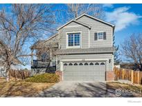Charming gray two-story home with an attached two-car garage and well-kept landscaping at 608 Bluegrass Dr, Longmont, CO 80503