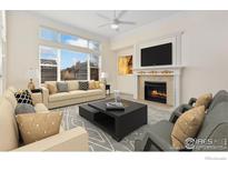 Spacious living room featuring a fireplace and large windows at 704 Windflower Dr, Longmont, CO 80504