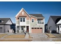 Charming two-story home with landscaped yard, covered porch, balcony, and attached two-car garage at 1591 Poplar Dr, Erie, CO 80516