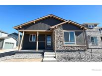 Charming single-Gathering home with a stone facade, neutral paint, and inviting front porch at 2263 Serenidad St, Brighton, CO 80601