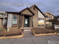 New construction home exterior boasts a modern design with large windows and a welcoming front porch at 2277 Serenidad St, Brighton, CO 80601