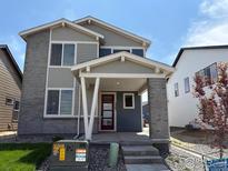 Charming two-story home featuring a welcoming front porch and modern architectural details at 2283 Serenidad St, Brighton, CO 80601