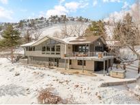 Two-story home with deck, hot tub, and mountain views in snowy setting at 230 Cactus Ct, Boulder, CO 80304