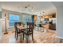 Bright dining room with wood floors and a view into the kitchen at 8093 Miller Cir, Arvada, CO 80005