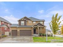 Two-story house with a double garage and landscaped yard at 1127 Highlands Dr, Erie, CO 80516