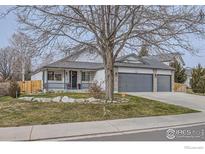 Ranch-style home with gray three-car garage and landscaped front yard at 1127 Red Oak Dr, Longmont, CO 80504