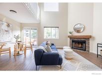 Open living room with vaulted ceiling, fireplace, and dining area at 6158 Habitat Dr, Boulder, CO 80301