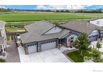 New construction home with two-car garage, landscaping, and a view of open fields at 808 Lowrey Ln, Berthoud, CO 80513