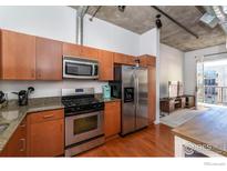 Modern kitchen with stainless steel appliances and wood cabinetry at 3701 Arapahoe Ave # 317, Boulder, CO 80303