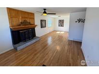 Spacious living room featuring hardwood floors, a decorative fireplace, and ample natural light at 6213 Gray St, Arvada, CO 80003