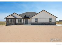 Two-story house with stone and white siding, a gray door, and a landscaped yard at 16474 Essex S Rd, Platteville, CO 80651