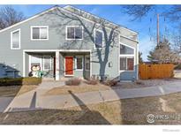 Two-story townhome with gray siding, orange door, and small front yard at 5174 Buckingham Rd, Boulder, CO 80301