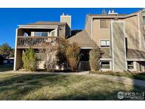 Tan two-story condo building with private balcony and landscaping at 5540 Stonewall Pl # 16, Boulder, CO 80303