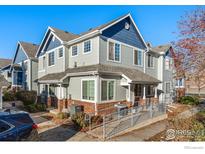 Two-story townhome with gray and blue siding, and a brick walkway at 12953 Lafayette St # C, Thornton, CO 80241