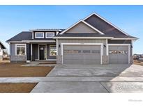 Gray house with stone accents and a three-car garage at 1369 Burt Ave, Berthoud, CO 80513