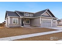 Gray two-story house with stone accents and a three-car garage at 1369 Burt Ave, Berthoud, CO 80513