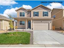 Two-story house with beige siding, gray shutters, and a two-car garage at 2236 Crosswind St, Fort Lupton, CO 80621