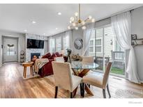 Bright dining area with glass table and modern chairs, adjacent to living room at 2428 Yukon Dr, Longmont, CO 80504