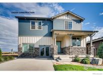 Two-story craftsman style home with blue and white siding, stone accents, and a covered porch at 2715 Crystal Springs, Longmont, CO 80503