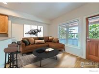 Bright living room with a brown sectional sofa, coffee table, and two stools at 3101 Iron Forge Pl # J-206, Boulder, CO 80301