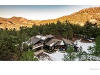 Stunning aerial view of a contemporary home nestled in a wooded mountain setting at 37 Wagner Cir, Boulder, CO 80304