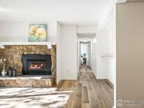 Living room with stone fireplace and hardwood floors at 6545 Kalua Rd # 203D, Boulder, CO 80301