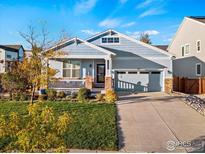 Ranch style home with light blue siding, stone accents, and landscaped yard at 747 Cristo Ln, Lafayette, CO 80026