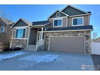 Two-story house with stone accents and a two-car garage at 1441 Murrlet St, Berthoud, CO 80513