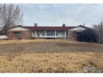 Ranch style home with a large covered porch and stone facade at 6397 Ute Hwy, Longmont, CO 80503