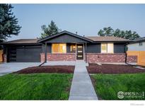 Brick ranch home with a modern dark gray exterior, updated landscaping, and a two-car garage at 6640 Pierce St, Arvada, CO 80003