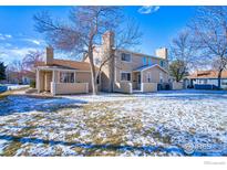 Backyard view of townhouse with snow-covered grass and patio at 8428 Everett Way # B, Arvada, CO 80005