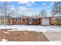 Brick ranch house with attached garage and snowy front yard at 115 17Th Ave, Longmont, CO 80501