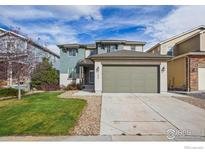 Two-story house with a green lawn and a large driveway at 1155 Mcmurdo Cir, Castle Rock, CO 80108