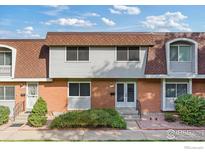 Brick front exterior of townhome with a well-maintained lawn at 12974 W Virginia Ave, Lakewood, CO 80228