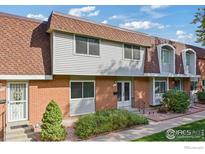 Brick townhouse with a brown roof and well-maintained landscaping at 12974 W Virginia Ave, Lakewood, CO 80228