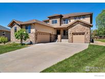 Two-story house with stone accents and a three-car garage at 13699 Pecos Loop, Broomfield, CO 80023