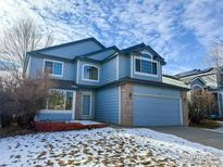 Two-story house with blue siding, brick accents, and a two-car garage at 1524 E Weldona Way, Superior, CO 80027