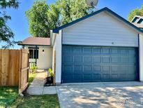 Updated home exterior featuring a new garage door and landscaping at 1801 Donovan Dr, Longmont, CO 80501